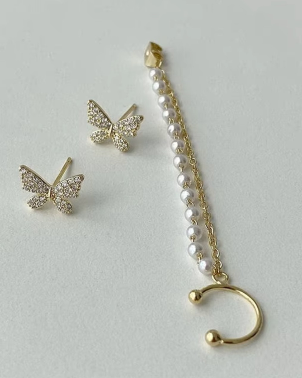 Elegant pearl tassel and butterfly chain earrings, perfect for sophisticated jewelry collections and stylish accessories.