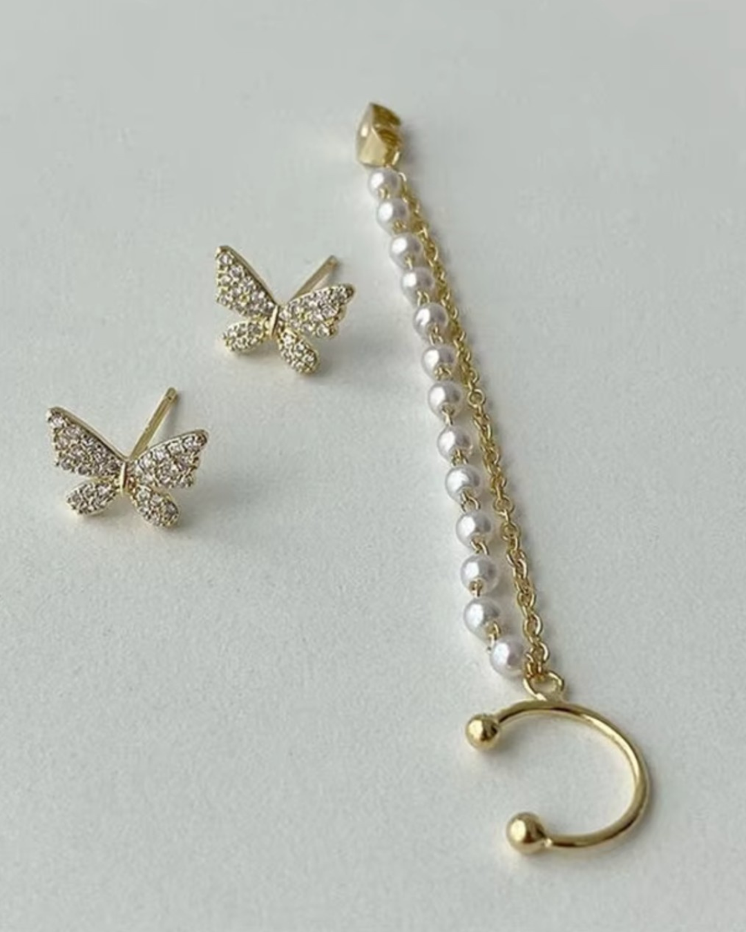 Elegant pearl tassel and butterfly chain earrings, perfect for sophisticated jewelry collections and stylish accessories.
